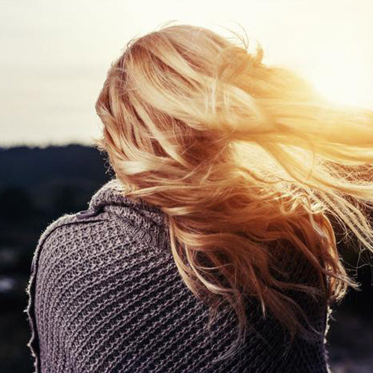 Läusefreie Haare einer Frau wehen im Wind
